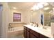 Bright bathroom with a tiled tub, double sinks, and ample counter space at 1169 Richmond Ln, Greenwood, IN 46143