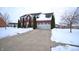 Two-story brick home with an attached garage and a concrete driveway covered in freshly fallen snow at 1169 Richmond Ln, Greenwood, IN 46143