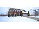 Two-story red brick home with a two-car garage and evergreen trees in a neighborhood with snow covered yards at 1169 Richmond Ln, Greenwood, IN 46143