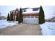 Two-story brick home with white garage door, evergreen trees, and snow covered yard and driveway at 1169 Richmond Ln, Greenwood, IN 46143