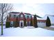 Red brick two-story home with shutters, evergreen trees, and a snowy front yard on a winter day at 1169 Richmond Ln, Greenwood, IN 46143