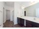 Bathroom featuring a double vanity with dark cabinets and a large mirror, plus wood-look floors at 1438 Willow Tree Ln, Sheridan, IN 46069