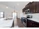 Modern kitchen showcasing stainless steel appliances, marble countertops, and dark cabinetry at 1438 Willow Tree Ln, Sheridan, IN 46069