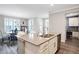 The bright kitchen has an island with a sink and stainless appliances with seamless transition to the dining room at 17330 Graley Pl, Westfield, IN 46074