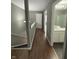 Upstairs hallway with hardwood floors leading to a bathroom with a shower and sink at 1881 Harvest Meadow Dr, Greenwood, IN 46143