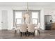 Bright dining room with modern chandelier, upholstered chairs, and large windows next to the kitchen at 2052 Bellefontaine St, Indianapolis, IN 46202