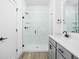 Modern bathroom featuring a glass enclosed shower with white subway tiles and black hardware, next to a gray vanity at 2149 N College Ave, Indianapolis, IN 46202