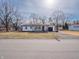 Well-kept single-story home featuring a bright exterior, a paved driveway, and mature trees at 2219 W 59Th St, Indianapolis, IN 46228
