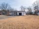Charming single-story home featuring a covered front porch, black trim, and an attached garage at 2219 W 59Th St, Indianapolis, IN 46228