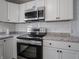 Updated kitchen with stainless steel appliances, granite countertops and white cabinetry at 2219 W 59Th St, Indianapolis, IN 46228