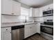 The kitchen features white cabinets, stainless steel appliances, and a gray backsplash at 2219 W 59Th St, Indianapolis, IN 46228