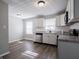 The kitchen features white cabinets, stainless steel appliances and gray countertops at 2219 W 59Th St, Indianapolis, IN 46228