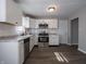 The kitchen features white cabinets, stainless steel appliances, and a gray backsplash at 2219 W 59Th St, Indianapolis, IN 46228