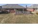 Home's backyard featuring a screened-in porch, brick exterior, and well-kept lawn at 223 Andrews Boulevard East Dr, Plainfield, IN 46168