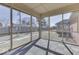 Enclosed sunroom with screened windows and tiled flooring, providing a view of the backyard at 223 Andrews Boulevard East Dr, Plainfield, IN 46168