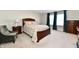 Well-lit bedroom featuring carpet, a wooden bed frame with two bedside tables, and blue curtains over a window at 28 Lively Pl, Cicero, IN 46034