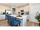 Modern kitchen island with white countertop, stainless steel appliances, and pendant lighting above blue cushioned chairs at 28 Lively Pl, Cicero, IN 46034