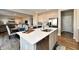 Open-concept kitchen island with stainless steel appliances, sink, and views to the dining and living areas at 28 Lively Pl, Cicero, IN 46034