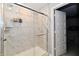 Modern tiled shower featuring glass door, modern fixtures, and shelving for bathroom products at 28 Lively Pl, Cicero, IN 46034
