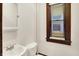 Bathroom features a vintage window with dark trim, vanity mirror, sink and toilet at 342 N Arsenal Ave, Indianapolis, IN 46201
