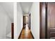 Long hallway with hardwood flooring and white walls leading to a bedroom at 342 N Arsenal Ave, Indianapolis, IN 46201