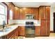 Well-lit kitchen features wooden cabinetry, granite counters, and black appliances at 342 N Arsenal Ave, Indianapolis, IN 46201
