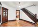Living room showcases original hardwood floors, a built-in cabinet, and easy staircase access at 342 N Arsenal Ave, Indianapolis, IN 46201