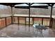 View of a wooden deck overlooking a treed backyard; furnished with a round patio table at 4050 Harmony Dr, Indianapolis, IN 46221