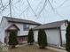Home featuring a well-maintained lawn, mature landscaping, and side entry garage at 4050 Harmony Dr, Indianapolis, IN 46221
