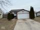 Charming home featuring a two-car garage, well-maintained lawn, and mature landscaping at 4050 Harmony Dr, Indianapolis, IN 46221