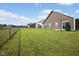 Large grassy backyard with a chain-link fence and a view of neighboring homes at 4236 Stubbington Ln, Indianapolis, IN 46239