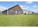 The backyard is spacious with green grass, a fence, and a sliding door entrance at 4236 Stubbington Ln, Indianapolis, IN 46239