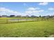 View of grassy backyard, fenced for privacy, with a pond and neighborhood homes in the distance at 4236 Stubbington Ln, Indianapolis, IN 46239