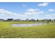 Picturesque pond surrounded by a grassy area with neighborhood homes in the background at 4236 Stubbington Ln, Indianapolis, IN 46239