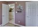 Hallway leading to another room, featuring white doors, neutral paint, and decorative wall hangings at 4349 W Summerhaven Dr, New Palestine, IN 46163