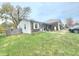 Side view of a home with brick accents, a partially fenced yard, and off-street parking at 5212 Bahia Dr, Indianapolis, IN 46237