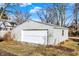 A one-car detached garage with white door and gray siding, blending into the backyard landscape at 529 W 42Nd St, Indianapolis, IN 46208