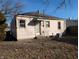 Back exterior view shows the home, with the window and modest yard at 603 W 33Rd St, Anderson, IN 46013