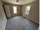 A bedroom featuring neutral walls, soft carpeting, and two windows for natural light at 603 W 33Rd St, Anderson, IN 46013