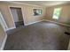 Bright living room with neutral walls, carpeted floors, and a view into the kitchen at 603 W 33Rd St, Anderson, IN 46013