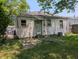 Shows the rear of the home, featuring a modest yard and classic architectural details at 603 W 33Rd St, Anderson, IN 46013