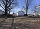 View of the backyard, partially shaded by trees, offering a serene outdoor space at 605 W 10Th St, Muncie, IN 47302