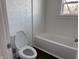Clean bathroom with a white toilet and a white tub with a shower at 605 W 10Th St, Muncie, IN 47302