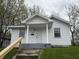 Charming white one-story home featuring a covered front porch and gray steps at 605 W 10Th St, Muncie, IN 47302