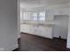 Well-lit kitchen with white cabinetry, neutral countertop, and stainless steel sink at 605 W 10Th St, Muncie, IN 47302