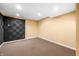 View of finished basement, including carpet, sound-dampening panels, recessed lighting, and tan painted walls at 685 Greystone Ct, Columbus, IN 47201