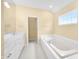 Bright bathroom features a soaking tub, double sink vanity, and large mirror at 685 Greystone Ct, Columbus, IN 47201