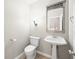 Elegant half bath with a pedestal sink, stylish mirror, and tile flooring at 685 Greystone Ct, Columbus, IN 47201
