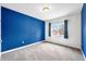 Bedroom features blue accent wall, carpeted floors, and natural light from a large window at 685 Greystone Ct, Columbus, IN 47201