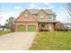 Charming two-story brick home featuring a well-manicured lawn, green shutters, and a two-car garage at 685 Greystone Ct, Columbus, IN 47201